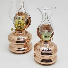 two glass vases sitting side by side on top of each other, one with a clock in it