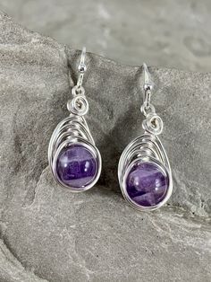 These beautiful genuine natural Amethyst earrings are truly unique. The violet purple color of the stone is beautiful in its simplicity. These amethysts smooth polished rounds that I chose to wire wrap in a simple herringbone design with silver plated wire to let the stone shine . These earrings are truly lovely. Each genuine Amethyst gemstone has been carefully selected for these earrings. They are made completely by hand by me. Pleasingly simple yet extraordinary, these earrings can be worn dr Marble Earrings, Herringbone Design, Carnelian Pendant, Irish Gifts, Violet Purple, Birthstone Gifts, February Birthstone, Celtic Jewelry, Amethyst Earrings