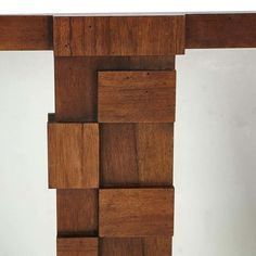 a close up of a wooden structure with squares on it's sides and a mirror in the background