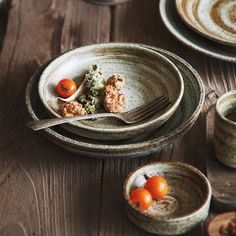 a plate with some food on it next to two bowls and a fork in the bowl