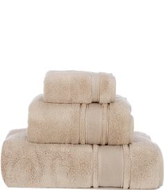 three towels stacked on top of each other in beige colors with white trimmings