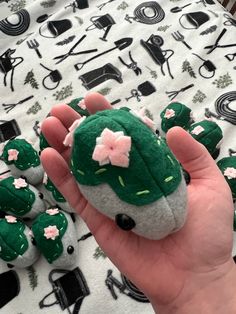 a hand is holding a small stuffed cactus