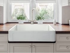 a white kitchen sink sitting under a window