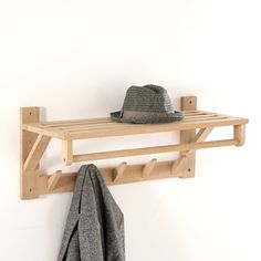 a hat and coat hanger on a white wall next to a gray towel rack