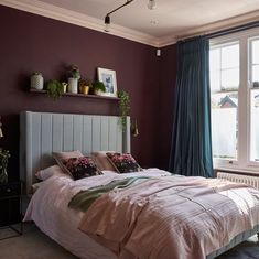 a bedroom with purple walls and white bedding