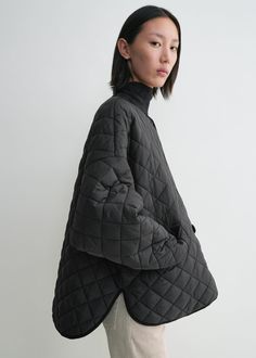 Oversized TOTEME quilted jacket cut to a billowing silhouette that dips effortlessly down the back, creating a chic A-line profile. It is made from water-resistant recycled polyester with dropped shoulders, snap buttons and side pockets, then is fitted with ribbed cuffs to keep you warm. Wear it as intended or go down a size for a more compact look. Oversized Black Quilted Outerwear, Oversized Quilted Jacket For Workwear, Oversized Quilted Long Sleeve Jacket, Oversized Quilted Jacket For Winter Workwear, Oversized Quilted Outerwear With Long Sleeves, Oversized Quilted Long Sleeve Outerwear, Oversized Quilted Jacket For Fall Workwear, Oversized Puffer Jacket With Pockets For Work, Oversized Quilted Puffer Jacket