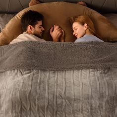 a man and woman laying in bed together