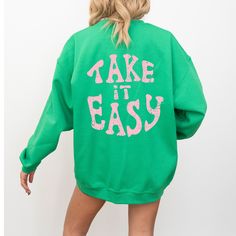 Embrace the nostalgic vibes with our "Take It Easy" crewneck sweatshirt in green, a perfect addition to your Y2K hoodie collection that radiates positivity and preppy aesthetic. This trendy pullover, adorned with an uplifting quote, is more than just a piece of clothing; it's a statement of ease and style. MATERIAL AND CARE  - Gildan 18000 -50% cotton, 50% polyester -Runs true to size - size up 1-2 sizes for an oversized look -Wash Inside Out In Cold Water PROCESSING AND SHIPPING  In effort to b Green Long Sleeve Hoodie With Graphic Print, Green Oversized Retro Sweater, Green Oversized Hoodie Sweatshirt, Green Letter Print Hoodie, Green Graphic Print Sweatshirt For Winter, Green Long Sleeve Sweater With Graphic Print, Green Hoodie Sweats For Fall, Green Oversized Sporty Sweats, Green Letter Print Sweatshirt For Winter