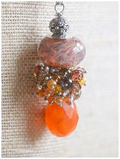 This pendant is a beautiful large Handmade Boro Glass bead made by a favorite glass artist of mine. The bead itself is almost 1" wide and 1/2" tall, and it has lovely depths to it. I added a large piece of Orange Carnelian, with more than 40 Swarovski crystals, carneilian drops and czech crystals, on a sterling silver chain, and a sterling silver lobster clasp. Necklace is approx 26 inches in length. Pendant is approximately 2 1/2" long. You'll love wearing this. I only make a few of these large Unique Faceted Glass Beads Jewelry, Handmade Glass Pendant Beaded Necklace, Handmade Spiritual Murano Glass Jewelry, Handmade Glass Teardrop Pendant Jewelry, Unique Glass Jewelry For Crafting, Handmade Orange Glass Necklaces, Handmade Orange Glass Necklace, Artisan Glass Pendant Necklace, Handmade Fusion Beaded Necklaces As Gift