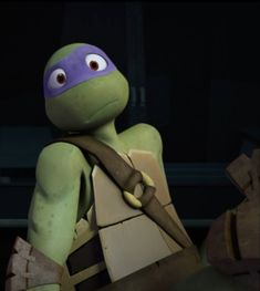 the teenage mutant in teenage mutant turtles is holding his arm out and looking at something