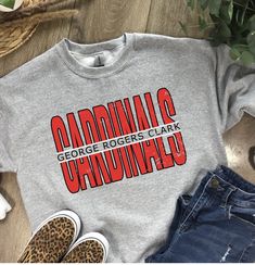 These GRC Cardinal shirts are a perfect addition to your school spirit wear!   ❗️Sizes: Toddler-2T-5T  Youth XS-XL  Adult S-XL  Adult 2X Adult 3X Available in short sleeve, long sleeve and sweatshirts!  Shirts are all unisex sizing! Shirt Color shown in Ash Gray and Sport Gray. Can do on any color, but design colors will not fully show on black or white shirts. This is a vinyl design on the shirt.  If you would like to request a custom order, please send us a message!! Team Spirit Sweatshirt With Logo Print For Game Day, Team Spirit Logo Print Sweatshirt For Game Day, Team Spirit Sweatshirt With Logo Print For Fans, Collegiate University Red Sweatshirt For Game Day, Collegiate Athletic Heather Tops For Game Day, Red Varsity Tops For Fan Gear, Collegiate Style Tops In Athletic Heather For Game Day, University Red Sporty Sweatshirt For Game Day, Sporty University Red Sweatshirt For Game Day