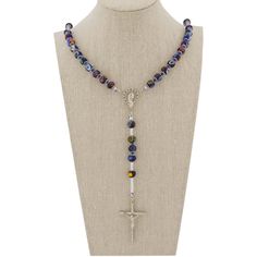 This Murano Glass Rosary Necklace features beautiful blue Millefiori beads and a silver-plated crucifix handcrafted by the skilled master glass-makers in a family-owned workshop on Murano island in Venice, Italy. The rosary necklace is created by hand using ancient glass-making tools and techniques. This is a beautiful religious gift with an Italian flair that will be uniquely appropriate for a special occasion. Measurements: Full Length is 27 inches. The length from the centerpiece to the botto Blue Crucifix Necklace For Spiritual Wear, Blue Crucifix Necklace For Spiritual Purposes, Blue Adjustable Cross Necklace, Adjustable Blue Cross Necklace, Beaded Crucifix Necklace, Blue Spiritual Beaded Necklace With Silver Beads, Spiritual Blue Beaded Necklace With Silver Beads, Spiritual Blue Beaded Necklaces With Silver Beads, Blue Cross-shaped Jewelry With 8mm Beads