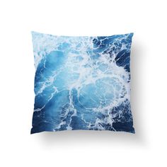 the ocean waves throw pillow is shown on a white background and features blue hues