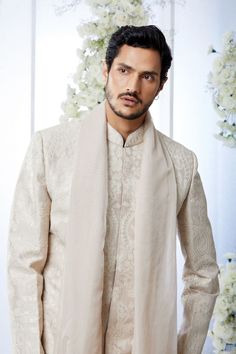 This sherwani set features all over matt sequin on a sand raw silk base. It is paired with off-white silk kurta and soften raw silk afghani salwar. Complimenting stole and footwear is also available.From Seema Gujral's Tuscan Summer collection. DELIVERY TIMEPlease allow 8-12 weeks for your outfit to arrive.FABRIC DETAILSRaw SilkProfessional cleaning only. Beige Raw Silk Sherwani With Dabka, Unstitched Beige Sherwani With Naqshi Detailing, Beige Sherwani With Dupatta Traditional Drape, Cream Raw Silk Sherwani With Dupatta, Cream Raw Silk Kurta With Traditional Drape, Traditional Beige Raw Silk Sherwani, Beige Raw Silk Sherwani With Zari Work, Beige Sherwani For Traditional Ceremonies And Festive Occasions, Unstitched Beige Sherwani With Zari Work