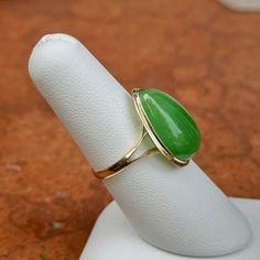 Estate 14KT yellow gold teardrop/ pear, large jade bezel-set band ring. Beautiful, vibrant, dyed green jade! Size 7 Weight: 3.73 grams Band width: 2mm Genuine jade measures: 20mm x15mm Stamped 14KT Excellent estate condition Jade Ring, Green Jade, Jade Green, Bezel Setting, Band Ring, Band Rings, Pear, Jade, Yellow Gold