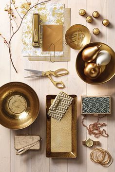 the table is set up with gold dishes and other items to decorate or display it