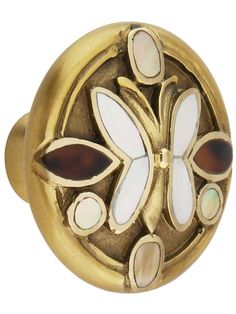 a close up of a gold colored knob with white and brown flowers on the front