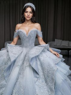 a woman in a blue ball gown is posing for the camera with her hands on her hips