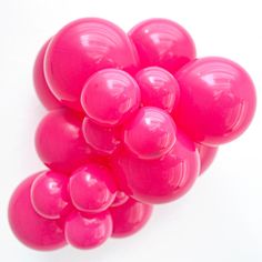 a bunch of pink balloons sitting on top of a white table