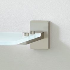 a white wall mounted shelf with two silver rings on it's edge and one is empty