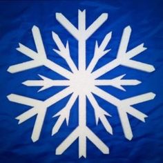 a snowflake on a blue background with white outlines in the shape of an arrow