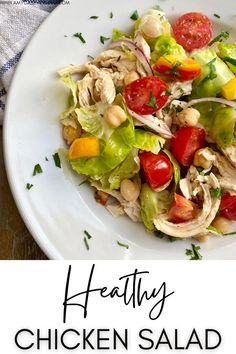 chicken salad with tomatoes, lettuce and chickpeas in a white bowl