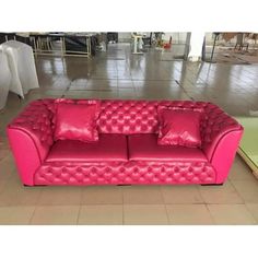 a pink couch sitting on top of a tiled floor