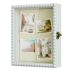 a white frame with four pictures hanging on it's sides and a keyhole in the middle