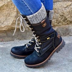 a close up of a person wearing boots and jeans with socks on the side walk