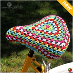 a close up of a bicycle with a crocheted seat cover