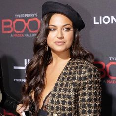 a woman in a black and gold jacket posing for the camera with a handbag on her shoulder