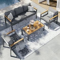 an aerial view of a living room with couches, chairs and coffee table in front of a swimming pool