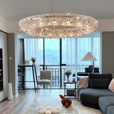 a living room filled with furniture and a chandelier hanging over the top of it