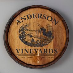 a wooden barrel mounted to the side of a wall with an advertisement for anderson's vineyards on it