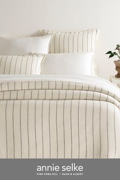 an image of a bed with white and black striped comforter set on top of it