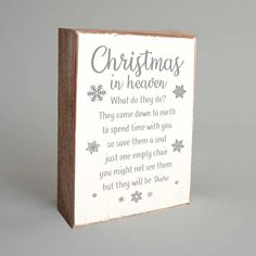 a wooden block with the words christmas in heaven written on it and snowflakes