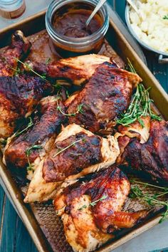 chicken wings with herbs and sauce on a tray next to mashed cauliflower