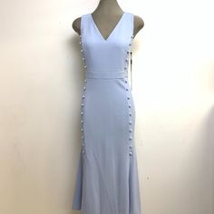 Elevate Your Wardrobe With This Stunning Calvin Klein Elegant Zen Light Blue Color, V-Neck Button Crepe Fit & Flare Dress In Size 6 And 12. This Dress Features A Flattering Front Button Sides Decoration Ending On Two Open Slits, A V-Neckline, Sleeveless Design, And A Zip Closure. The Crepe Fabric Gives It A Structured And Luxurious Feel, While The High Quality Poly/Spandex Material Ensures Comfort And Ease Of Movement. The Dress Comes In A Beautiful Blue Color And Features A Bohemian Theme, Perf Fitted V-neck Dress With Buttons For Spring, Blue V-neck Midi Dress With Buttons, Light Blue Sleeveless Dress With Buttons, Spring Fitted V-neck Dress With Buttons, Spring Calvin Klein Dress With Button Closure, Calvin Klein Spring Dresses With Button Closure, Chic Calvin Klein V-neck Midi Dress, Chic Calvin Klein Midi Dress With V-neck, Calvin Klein Summer V-neck Midi Dress