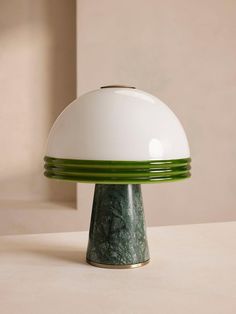 a green and white lamp sitting on top of a table