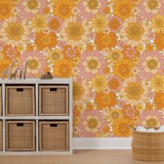 an orange and yellow floral wallpaper with baskets on the floor in front of it