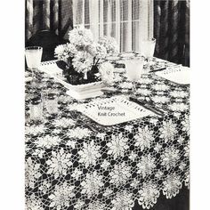 the table cloth is black and white with lace on it, along with vases filled with flowers