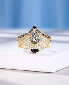 a diamond ring sitting on top of a white box with black and white diamonds around it