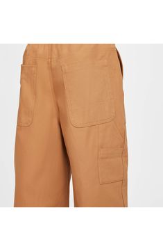 Your child will find uses for every one of the pockets while playing hard in these wide-leg carpenter pants made from durable cotton canvas. 25 1/2" inseam; 22" leg opening; 14" front rise; 15" back rise (size XL) Zip fly with button closure Back elastic waist Front slant pockets; back patch pockets; tool pockets 100% cotton Machine wash, tumble dry Imported Nike Cargo Bottoms, Utility Cotton Work Pants With Elastic Waistband, Fall Cotton Wide Leg Pants With Cargo Pockets, Cotton Utility Wide Leg Pants, Utility Style Full Length Wide Leg Cotton Pants, Utility Style Cotton Wide Leg Pants, Full Length Cotton Wide Leg Utility Pants, Utility Wide Leg Cotton Pants With Patch Pockets, Utility Style Cotton Wide Leg Pants With Patch Pockets