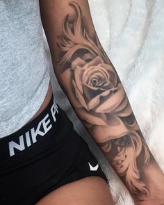 a woman's arm with a rose tattoo on the left side of her body