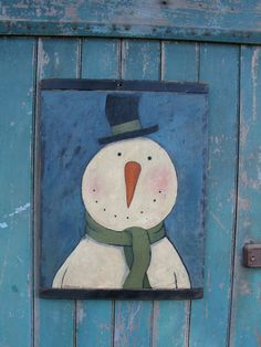 a snowman painted on the side of a blue door with a green scarf around his neck