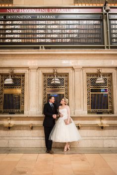 a bride and groom standing in front of the new york stock exchange