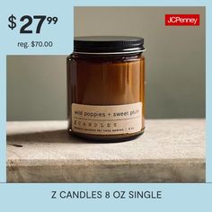 a candle is sitting on a table with the price tag below it for $ 27 99