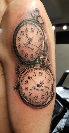 a man with a tattoo on his arm has two clocks in the shape of an alarm clock