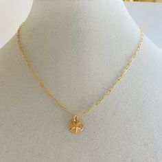 A sand dollar coin dangles from a delicate gold chain. The chain measures approximately 17 inches long is adjustable up to an inch shorter. Dainty Adjustable Charm Necklace With Coin Pendant, 14k Gold Filled Charm Necklace With Coin Pendant, Delicate Charm Necklace With Round Coin Pendant, Dainty Gold Starfish Charm Necklace, Adjustable Yellow Gold Charm Necklace With Coin Pendant, Gold Charm Necklace With Starfish Charm, Adjustable Yellow Gold Coin Necklace, Adjustable Dainty Coin Pendant Jewelry, Gold Adjustable Round Disc Charm Necklaces