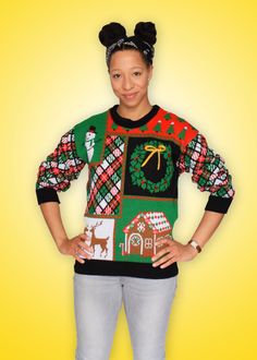 a woman standing in front of a yellow background wearing an ugly sweater with christmas decorations on it